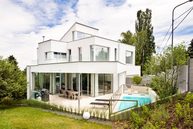 Großes, Dreistöckiges Modernes Einfamilienhaus mit Putzfassade und weißer Fassadenfarbe in Sonstige