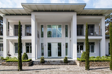 Zweistöckiges, Großes Modernes Haus mit Putzfassade, beiger Fassadenfarbe und Flachdach in Sonstige