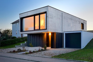 Kleines, Zweistöckiges Modernes Haus mit Betonfassade, Flachdach und grauer Fassadenfarbe in München
