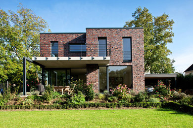 Ispirazione per la facciata di una casa grande marrone contemporanea a due piani con rivestimento in mattoni e tetto piano