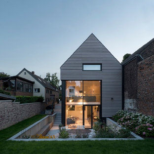 Inspiration för ett mellanstort funkis grått hus, med tre eller fler plan och sadeltak