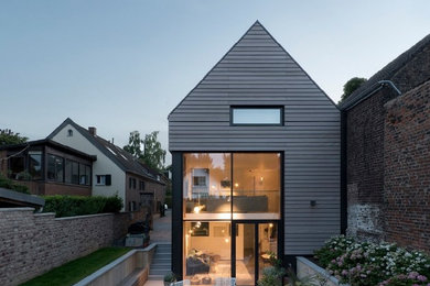 Mittelgroßes, Dreistöckiges Modernes Haus mit grauer Fassadenfarbe und Satteldach in Düsseldorf