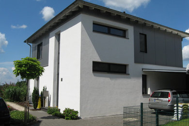 Inspiration for a white and medium sized contemporary two floor render house exterior in Dortmund with a hip roof.