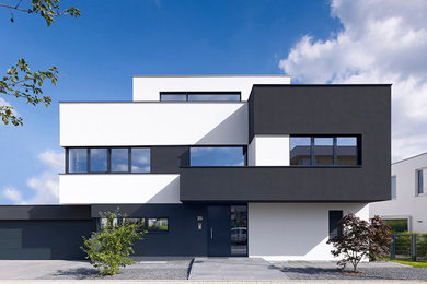 Großes, Dreistöckiges Modernes Haus mit schwarzer Fassadenfarbe und Flachdach in Köln