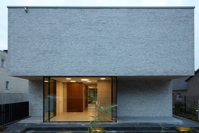 Ispirazione per la facciata di una casa grande beige moderna a due piani con rivestimento in mattoni e tetto piano