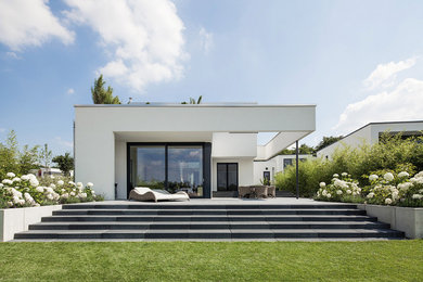 Einstöckiges, Mittelgroßes Modernes Haus mit weißer Fassadenfarbe und Flachdach in Hannover