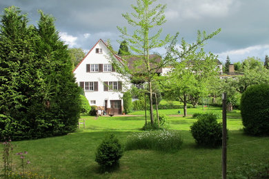 Kleines, Zweistöckiges Retro Einfamilienhaus mit Putzfassade, weißer Fassadenfarbe, Satteldach und Ziegeldach in Stuttgart