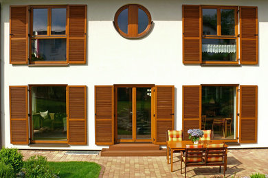 Mittelgroßes, Zweistöckiges Country Einfamilienhaus mit Lehmfassade, weißer Fassadenfarbe, Satteldach und Ziegeldach in Frankfurt am Main
