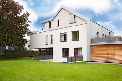 Aménagement d'une grande façade de maison blanche contemporaine à deux étages et plus avec un revêtement mixte et un toit à deux pans.