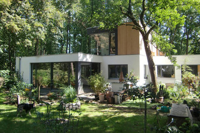 Modelo de fachada de casa blanca moderna con revestimiento de madera, tejado plano y tablilla