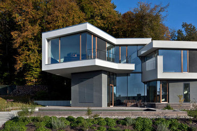 Mittelgroßes Modernes Haus mit grauer Fassadenfarbe, Flachdach und Mix-Fassade in Stuttgart