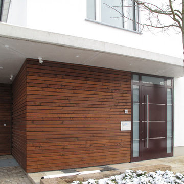 Eingangsbereich mit Holzfassade und Vordach aus Sichtbeton