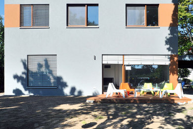 Zweistöckiges, Mittelgroßes Modernes Haus mit Putzfassade, grauer Fassadenfarbe und Flachdach in Berlin