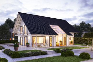 Cette photo montre une grande façade de maison blanche chic en stuc avec un toit à deux pans et un toit en tuile.