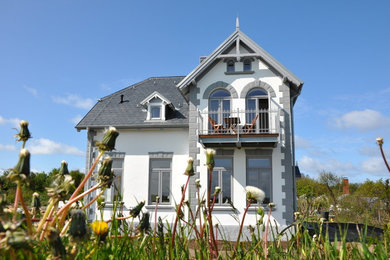 Mittelgroßes, Zweistöckiges Klassisches Haus mit Putzfassade, weißer Fassadenfarbe und Halbwalmdach in Sonstige