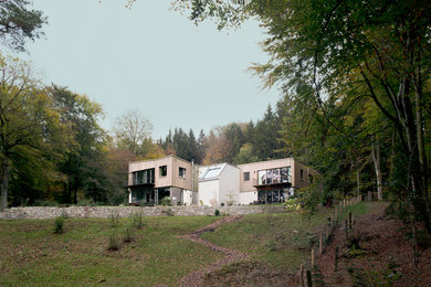 Foto della facciata di una casa grande grigia contemporanea a due piani con rivestimento in legno e tetto piano