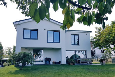 Mittelgroßes, Zweistöckiges Modernes Einfamilienhaus mit Putzfassade, weißer Fassadenfarbe, Satteldach und Ziegeldach in Köln
