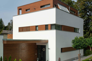 Mittelgroßes, Dreistöckiges Modernes Haus mit weißer Fassadenfarbe und Flachdach in München