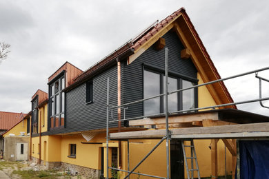 Zweistöckiges Mediterranes Haus mit grauer Fassadenfarbe, Satteldach und Ziegeldach in Berlin