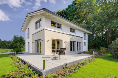 Réalisation d'une façade de maison blanche design de taille moyenne et à un étage avec un revêtement mixte, un toit à deux pans et un toit en shingle.