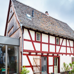 Mittelgroßes, Dreistöckiges, Weißes Landhaus Einfamilienhaus mit Mix-Fassade, Satteldach und Schindeldach in Frankfurt am Main