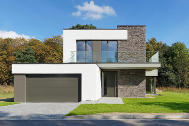 Imagen de fachada minimalista de tamaño medio de dos plantas con tejado plano y revestimientos combinados