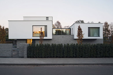 Mittelgroßes, Zweistöckiges Modernes Einfamilienhaus mit Flachdach, Mix-Fassade und bunter Fassadenfarbe in Berlin