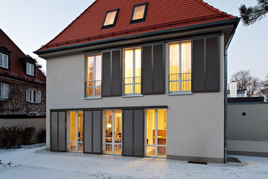 Mittelgroßes, Dreistöckiges Klassisches Haus mit beiger Fassadenfarbe und Walmdach in München