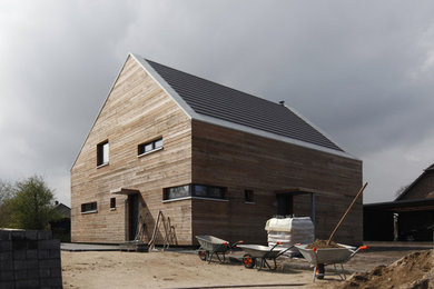 Aménagement d'une grande façade de maison marron contemporaine en bois à un étage.