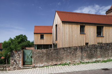 Mittelgroßes, Zweistöckiges Skandinavisches Haus mit brauner Fassadenfarbe, Satteldach und Schindeldach in Frankfurt am Main