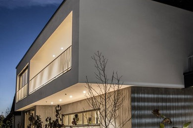 Zweistöckiges, Mittelgroßes Modernes Haus mit Betonfassade, Flachdach und grauer Fassadenfarbe in München