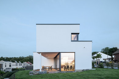 Mittelgroßes, Zweistöckiges Modernes Haus mit Putzfassade, weißer Fassadenfarbe und Flachdach in Sonstige