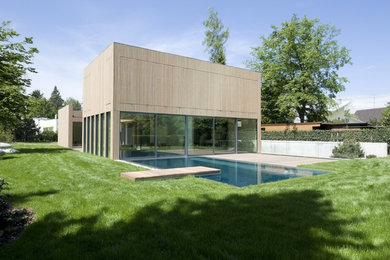 Mittelgroße, Zweistöckige Moderne Holzfassade Haus mit brauner Fassadenfarbe und Flachdach in München