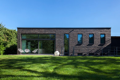 Inspiration pour une très grande façade de maison minimaliste en brique de plain-pied avec un toit plat.