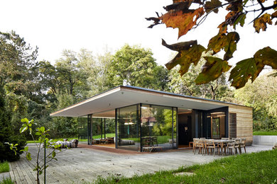 Ejemplo de fachada de casa marrón moderna de tamaño medio de una planta con revestimiento de madera y tejado plano