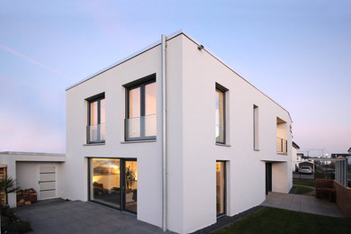 Zweistöckiges Modernes Haus mit Putzfassade, grauer Fassadenfarbe und Flachdach in Bonn