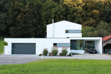Großes Modernes Haus mit weißer Fassadenfarbe und Satteldach in Sonstige