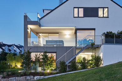 Großes, Dreistöckiges Modernes Einfamilienhaus mit Putzfassade, weißer Fassadenfarbe und Satteldach in Stuttgart
