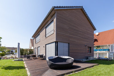 Ejemplo de fachada de casa marrón contemporánea de tamaño medio de dos plantas con revestimiento de madera y tejado de teja de barro