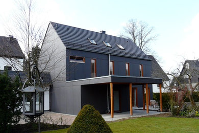 Идея дизайна: двухэтажный, черный частный загородный дом в стиле модернизм с черепичной крышей
