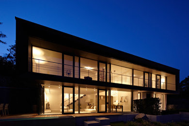Geräumiges, Zweistöckiges Modernes Einfamilienhaus mit Mix-Fassade, schwarzer Fassadenfarbe und Flachdach in Sonstige