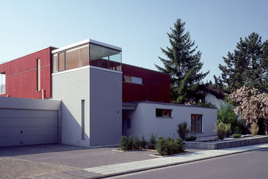 Diseño de fachada roja contemporánea de tamaño medio de dos plantas con revestimientos combinados y tejado plano
