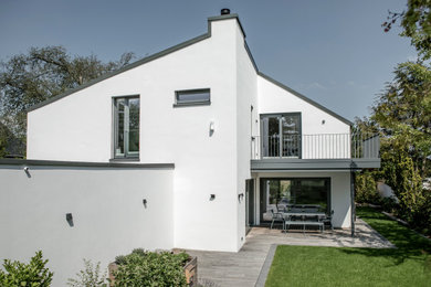 Geräumiges, Einstöckiges Modernes Einfamilienhaus mit Putzfassade, weißer Fassadenfarbe, Blechdach, Satteldach und grauem Dach in Düsseldorf