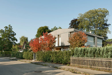 Réalisation d'une façade de maison beige design en bois de taille moyenne et à un étage avec un toit à deux pans.
