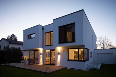 Geräumiges, Zweistöckiges Modernes Haus mit Putzfassade, weißer Fassadenfarbe und Flachdach in München