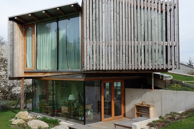 Imagen de fachada marrón contemporánea pequeña de dos plantas con revestimiento de madera y tejado de un solo tendido