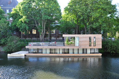 Zweistöckige, Mittelgroße Moderne Holzfassade Haus mit Flachdach und brauner Fassadenfarbe in Hamburg