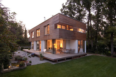 Mittelgroße, Zweistöckige Moderne Holzfassade Haus mit Flachdach und brauner Fassadenfarbe in München