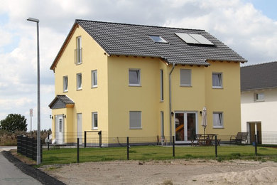 Großes, Dreistöckiges Klassisches Einfamilienhaus mit Putzfassade, gelber Fassadenfarbe, Satteldach, Ziegeldach und schwarzem Dach in Frankfurt am Main