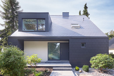 Einstöckiges Modernes Einfamilienhaus mit Faserzement-Fassade, schwarzer Fassadenfarbe, Satteldach und Schindeldach in Hamburg